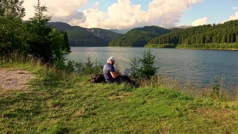 Mountain man working with laptop in the mountains Stock Footage 113570092