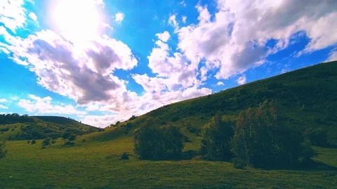 Mountain meadow timelapse at the summer. Clouds, trees, green grass and sun rays Stock Footage 127384202