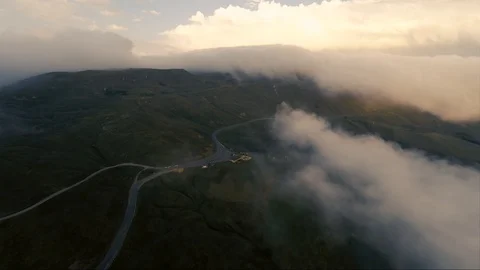 Mountain pass road in the clouds on golden sunset Stock Footage 102189807