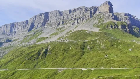 Mountain pass road  revealing steep cliffs and summit,with traffic, hikers, alps Stock Footage 283268108