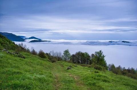 Mountain path above the clouds Stock Photos