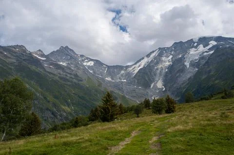 Mountain path facing Glacier de Bionnassay peaks Stock Photos