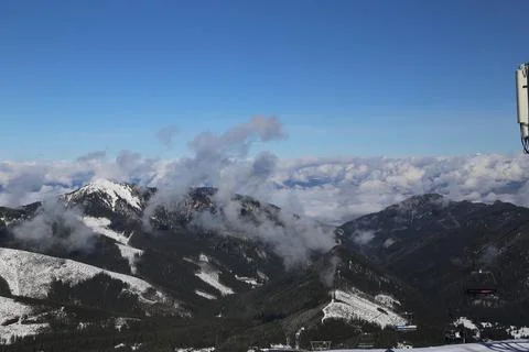 Mountain peak with cloud wisps above ski resort valley Fotos Stock