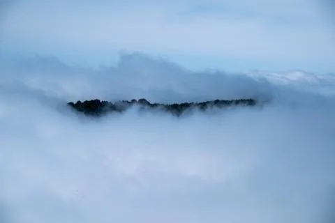 A mountain peak in the clouds Stock Photos