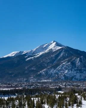 Mountain peak during the winter with pine trees and a valley Stock Photos