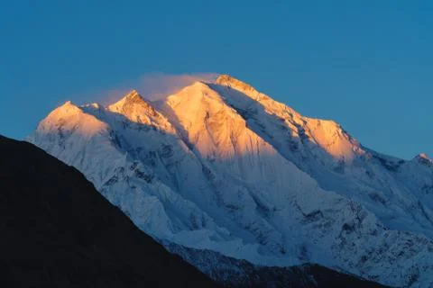 Mountain peak with first sunlight during sunrise on top in the morning Stock Photos
