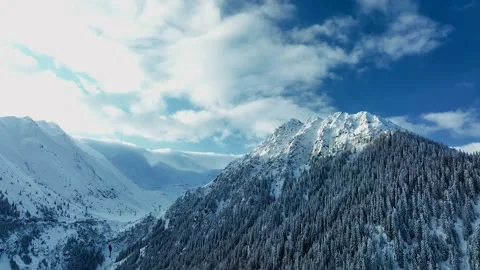 Mountain peak range aerial view snow winter blue sky with clouds morning sunrise Stock Footage 171479915