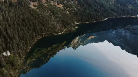 Mountain peak reflection in the lake water at sunrise. Alpine lake at morning Stock Footage 120581956