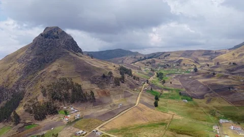 Mountain peak rising above patchwork farmlands and rural dwellings, revealing 스톡 동영상 308400989