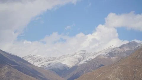 Mountain peak with some clouds and clear blue sky Stock Photos