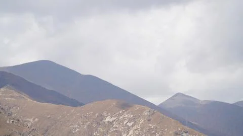 Mountain peak with some clouds and clear blue sky Stock Photos