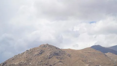 Mountain peak with some clouds and clear blue sky Stock Photos