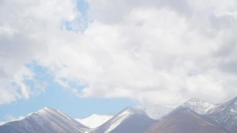 Mountain peak with some clouds and clear blue sky Stock Photos
