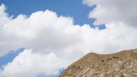 Mountain peak with some clouds and clear blue sky Stock Photos