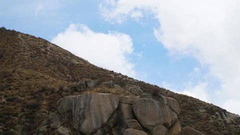 Mountain peak with some clouds and clear blue sky Stock Photos