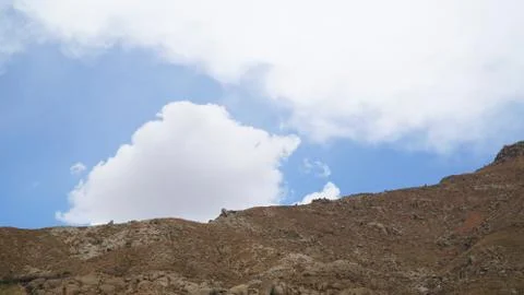 Mountain peak with some clouds and clear blue sky Stock Photos