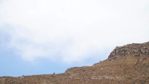 Mountain peak with some clouds and clear blue sky Stock Photos