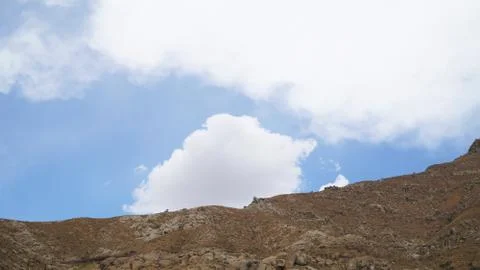 Mountain peak with some clouds and clear blue sky Stock Photos