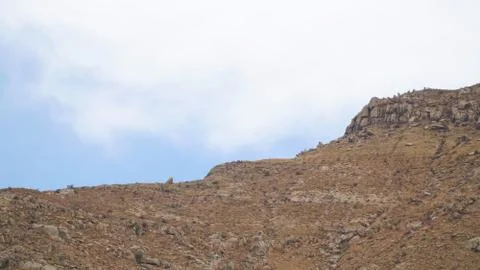 Mountain peak with some clouds and clear blue sky Stock Photos