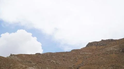 Mountain peak with some clouds and clear blue sky Stock Photos