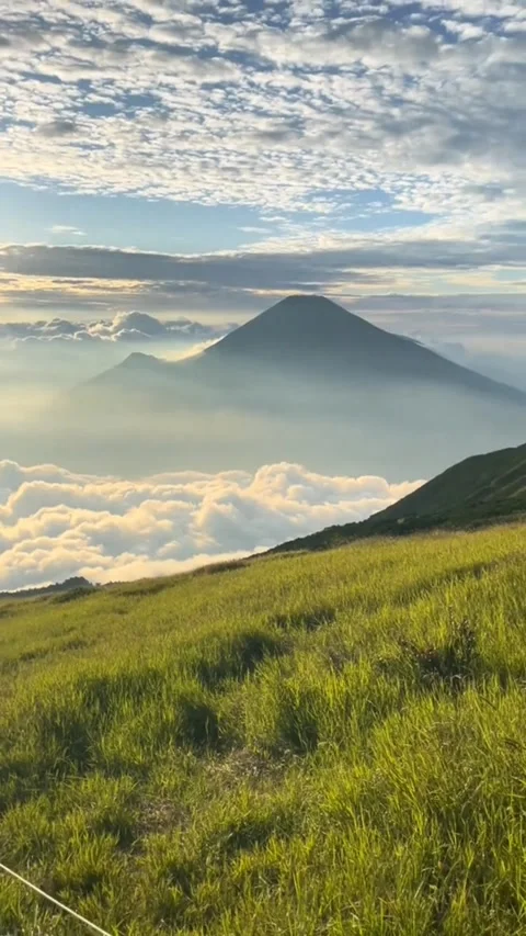 Mountain Peak Surrounded by White Clouds Under Bright Sunlight Stock Footage 313620210