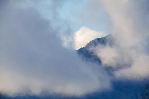 Mountain Peak Through Thick Cloud Cover Stock Photos