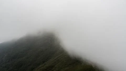Mountain Peak Wrapped in Rolling Mist and Ethereal Fog Clouds Time-lapse Stock Footage 326703266