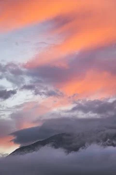 Mountain peaking out of the clouds Stock Photos