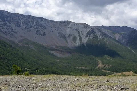 Mountain peaks against the backdrop of a cloudy sky Stock Photos