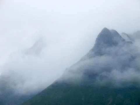 Mountain peaks covered with clouds Stock Photos