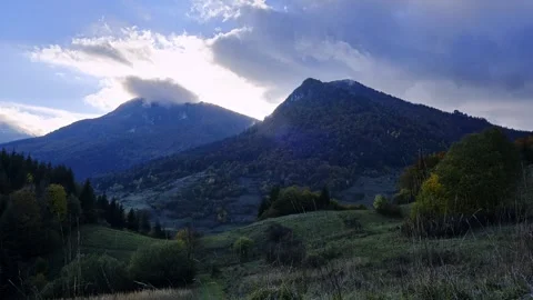 Mountain peaks covered with rolling rainy clouds, mountain ridge in evening dusk Stock Footage 255992682