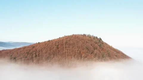 Mountain peaks in distance on horizon. Drone flies over clouds on sunny autumn Stock Footage 293125831