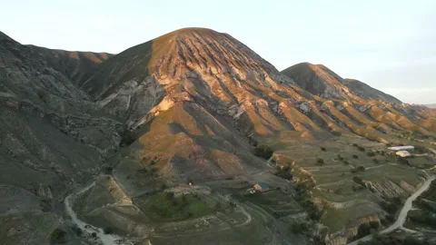Mountain peaks in the rays of the setting sun, aerial view, drone video. Stock Footage