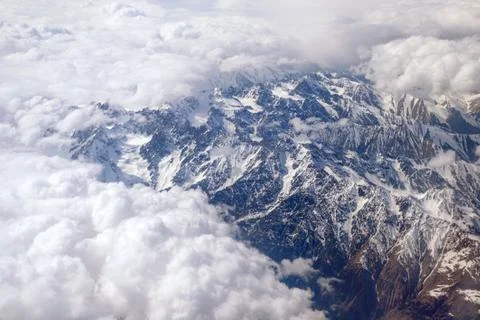 Mountain peaks through the clouds Stock Photos