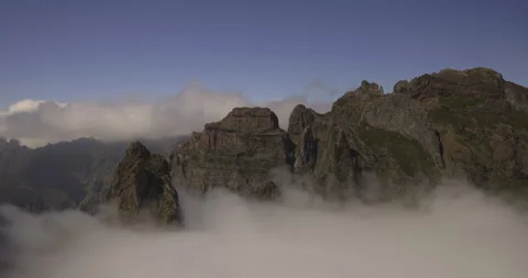 Mountain peaks wrapped in a ribbon of clouds, 4K Stock Footage 246367796