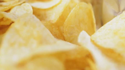 A mountain of potato chips lies on the table. Golden chips close-up. Video stock 220039001