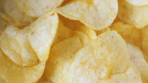 A mountain of potato chips lies on the table. Golden chips close-up. Lots of Stock-Footage 220085380