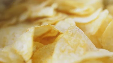 A mountain of potato chips lies on the table. Golden chips close-up. Lots of Stock Footage 220455625