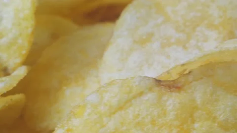 A mountain of potato chips lies on the table. Golden chips close-up. Lots of Stock-Footage 220979631