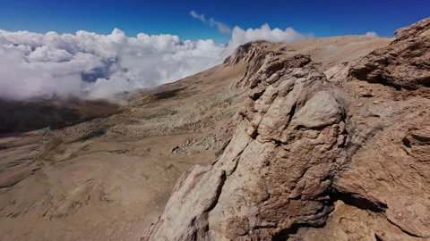 Mountain range aerial view capturing jagged peaks rising through misty cloud Stock Footage 304528208