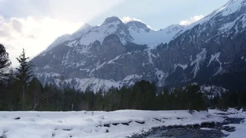 Mountain range in the Alps with a snowy river and forest, in Switzerland Stock Footage 239717685