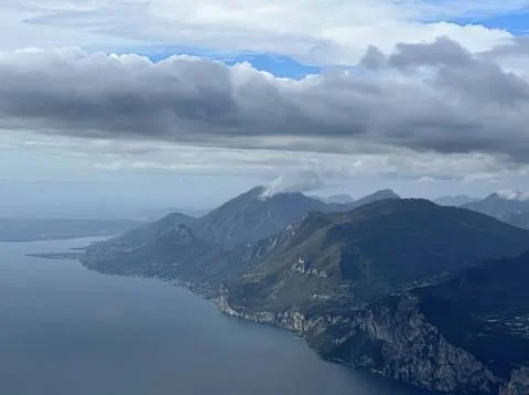 Mountain range and coastline under cloudy sky Stock Photos