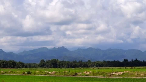 Mountain Range and Lush Green Agricultural Fields Under a Cloudy Sky Video stock 346239033