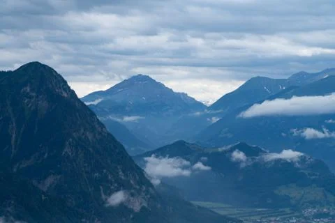 A mountain range and a valley in the clouds - blue colors Stock Photos