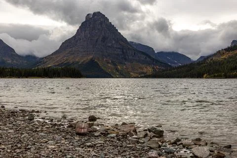 A mountain range is in the background with a lake in the foreground Stock Photos