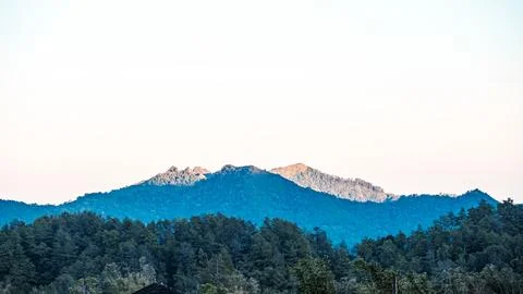 A mountain range with a blue sky in the background Stock Photos
