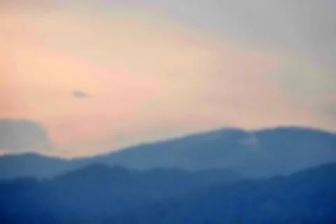 A mountain range with a blue sky in the background Stock Photos