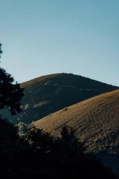 A mountain range with a blue sky in the background Stock Photos