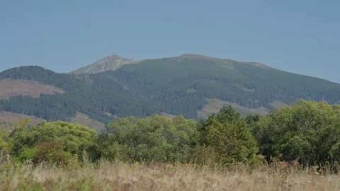 A mountain range with a clear blue sky in the background Stock Footage 298062315