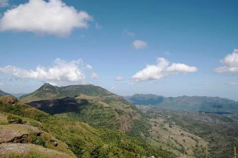 A mountain range with a clear blue sky and clouds Stock Photos